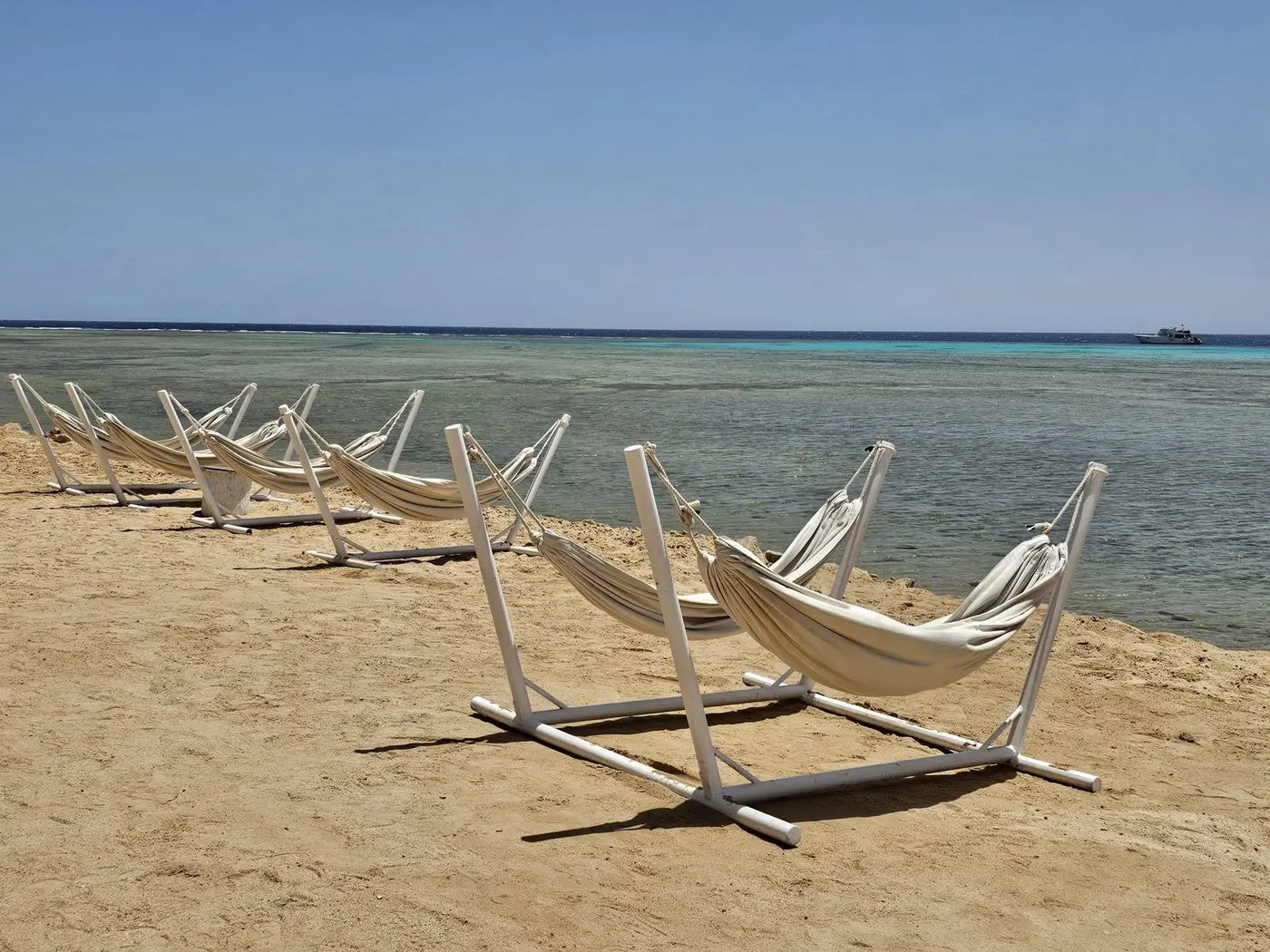 White hammocks beside the clear Red Sea in Somabay